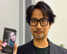 Hideo Kojima mostrando un póster de Physint en su teléfono