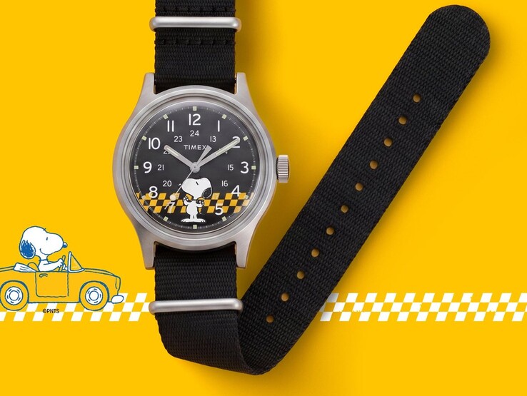 Reloj Peanuts x Timex MK1 con esfera negra en la que aparecen Snoopy y un diseño a cuadros amarillos y negros, mostrado con su correa de tela negra sobre un fondo amarillo.