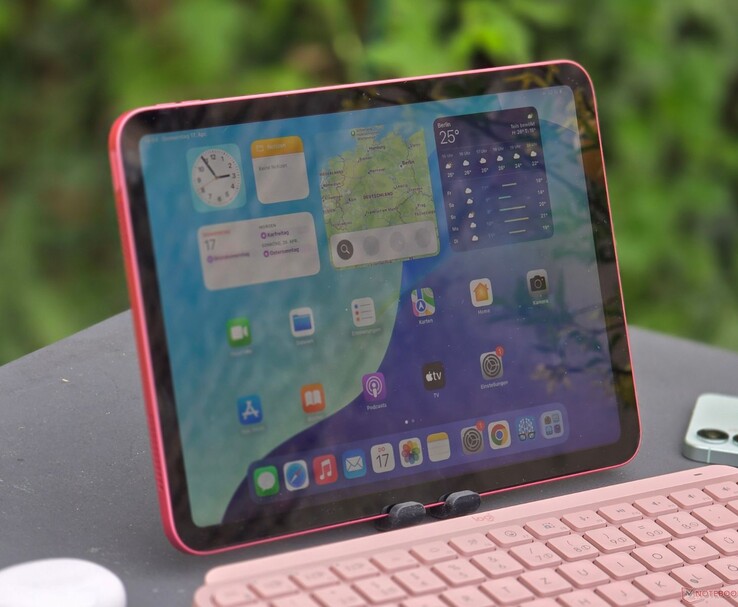 IPad rosa colocado al aire libre con la pantalla encendida y un teclado rosa delante. (Fuente de la imagen: Notebookcheck)