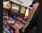 El coleccionista de máquinas de pinball neozelandés Kim Michael Dozier jugando con una máquina de pinball de Iron Maiden en Kimzone