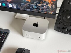 Un Mac mini con chip Apple M6 sobre un escritorio, formando parte de una configuración para videojuegos con monitor, teclado, ratón y altavoz.