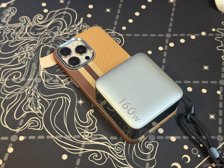 El Ugreen Nexode Pro de 160 W con cinco puertos, situado encima del iPhone 16 Pro Max