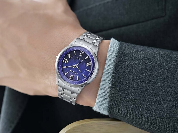 El Citizen Exceed CB1140-79L en la muñeca, mostrando su esfera azul, caja plateada y brazalete integrado de titanio sobre una chaqueta oscura.