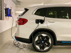 Un coche eléctrico enchufado en una estación de carga (Fuente de la imagen: Eren Goldman vía Unsplash)