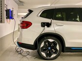 Un coche eléctrico enchufado en una estación de carga (Fuente de la imagen: Eren Goldman vía Unsplash)