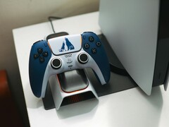 Un mando DualSense personalizado con temática de God of War descansa sobre una base de carga frente a una consola PlayStation 5. (Fuente de la imagen: FOX ^.ᆽ.^= ∫)