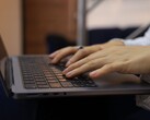 Manos tecleando en el teclado de un ordenador portátil en la oscuridad