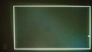 Cuando el proyector Yaber T1 Pro no está alineado en línea recta hacia una pared, ajusta la imagen para que aparezca nivelada recortando la proyección. En la zona no utilizada (arriba a la izquierda) queda visible un sangrado de luz muy débil. (f/1,6 3/10 seg ISO 3200) (Fuente de la imagen: Notebookcheck)