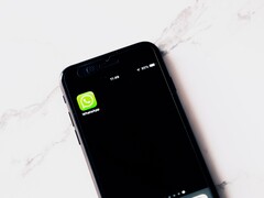 Un smartphone sobre una mesa blanca en el que se ve la aplicación de WhatsApp