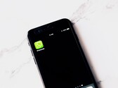 Un smartphone sobre una mesa blanca en el que se ve la aplicación de WhatsApp