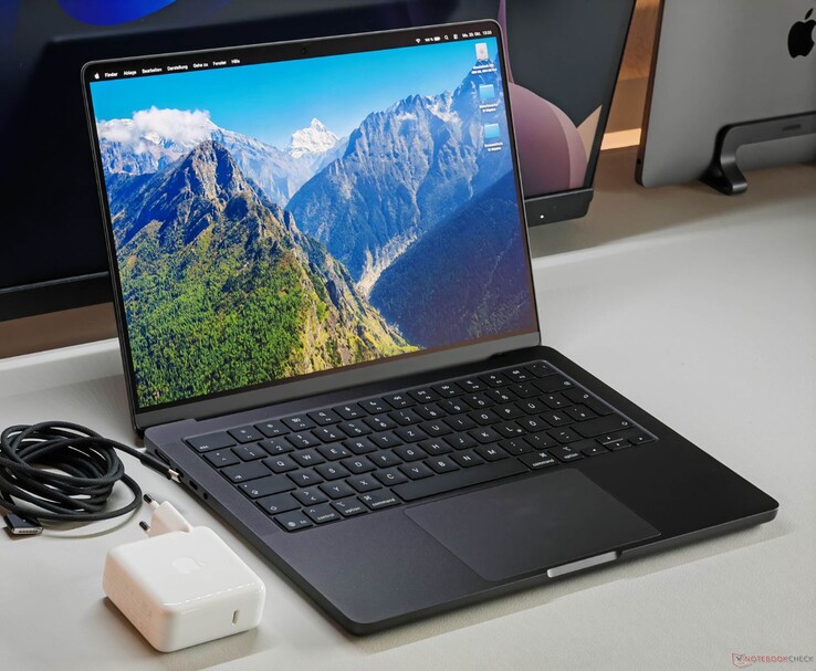 Apple MacBook Pro con chip M5 sobre un escritorio junto a su cargador y cable. (Fuente de la imagen: Notebookcheck)