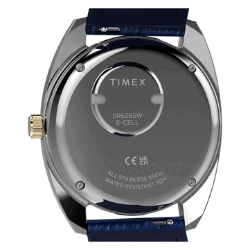 Vista posterior del Timex Q 1976 Day and Date en tono dorado, que muestra el fondo de caja de acero inoxidable, el compartimento de la pila y la indicación de resistencia al agua de 50 metros.