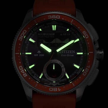 Captura con poca luz del Citizen Promaster Wave Tracker JV3000-13E en la que se aprecian las manecillas y los marcadores horarios brillantes sobre un fondo oscuro.