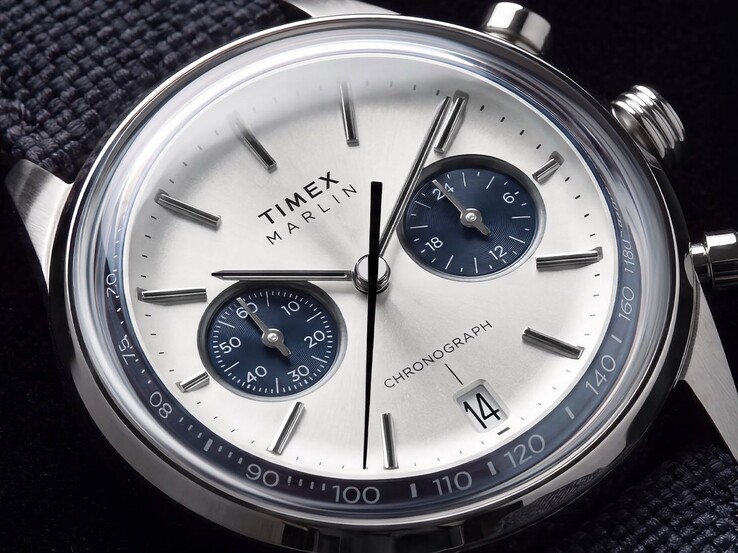 Primer plano del cronógrafo Timex Marlin Jet TW2Y89900, en el que se aprecian su esfera de color blanco plateado, las subesferas azul marino, los índices aplicados, las agujas tipo bastón, la escala taquimétrica y la ventana de la fecha.