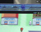 Primer plano de la consola portátil FPGBA SP azul transparente ejecutando Pokémon, con un contador de 59.74 FPS visible.