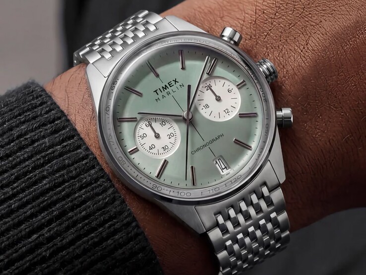 El cronógrafo Timex Marlin Jet, con esfera de color verde salvia y brazalete de acero inoxidable, lucido en la muñeca, muestra su cristal abombado y el perfil redondeado de su caja, de estilo retrofuturista.