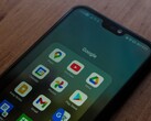 Un smartphone sobre un escritorio de madera con una carpeta de la aplicación de Google abierta