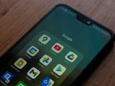 Un smartphone sobre un escritorio de madera con una carpeta de la aplicación de Google abierta