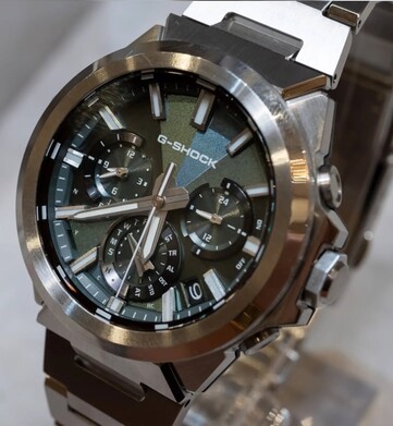 Primer plano del Casio G-Shock GST-W1000D-3A con esfera verde, en el que se aprecian su esfera con textura geométrica, sus tres subesferas, sus índices luminosos y su bisel de acero inoxidable pulido.