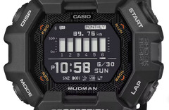 Reloj Casio G-Shock Mudman GDG-B100 con pantalla digital roja y blanca ante un paisaje montañoso escarpado.