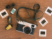 La nueva función del desarrollador para las cámaras Fujfilm se integrará en la aplicación Fujistyle ya existente. En la imagen, la cámara Fujfilm X100V junto a varios rollos de película. (Fuente de la imagen: Fuji X Weekly)