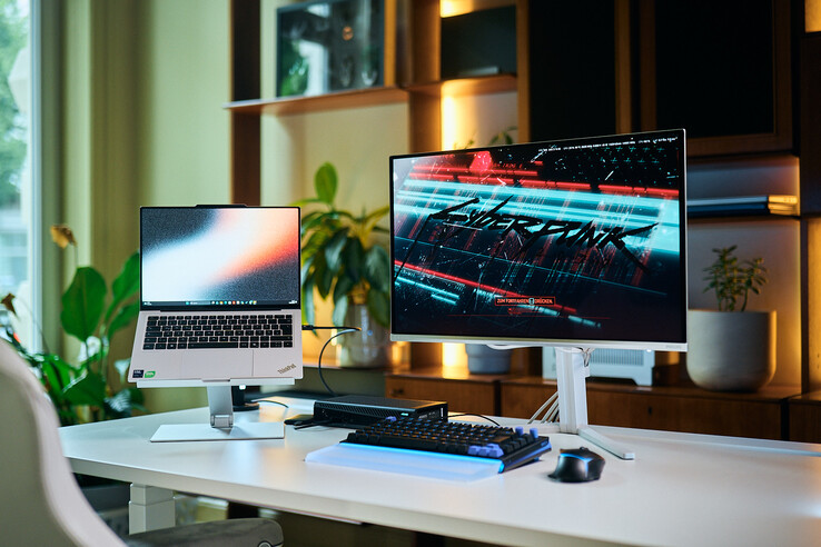 Configuración completa de una estación de trabajo que incluye un portátil ThinkPad X9 14 sobre un soporte, una eGPU Aorus RTX 5060 Ti AI Box y un monitor externo en el que se muestra Cyberpunk 2077.
