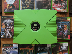 Una Xbox de color verde con 10 títulos retro de Xbox ilustrados