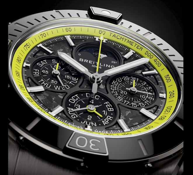 Primer plano del Breitling Super Chronomat B19 44 Perpetual Calendar Chronograph que muestra su esfera de fibra de carbono, las subesferas del calendario, las agujas de tono plateado y la escala taquimétrica de color verde lima.