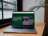 Un ordenador portátil sobre un escritorio junto a una ventana, con la página web de OpenAI ChatGPT abierta en la pantalla.