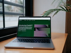Un ordenador portátil sobre un escritorio junto a una ventana, con la página web de OpenAI ChatGPT abierta en la pantalla.