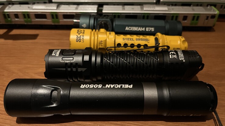 La SK-07 amarilla de Loop Gear comparada con la Acebeam E75 (atrás), la Nitecore P27i y la Pelican 5050R