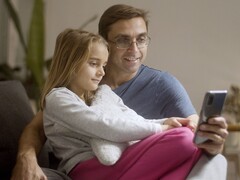 Un padre y su hija mirando juntos un smartphone