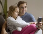 Un padre y su hija mirando juntos un smartphone