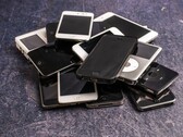 Montón de teléfonos inteligentes en desuso sobre una superficie gris