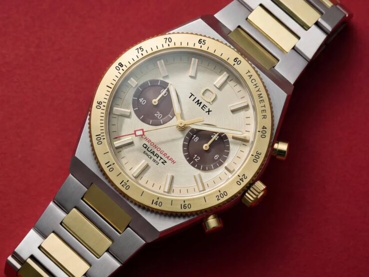 Primer plano del cronógrafo Timex Q Timex Continental TW2Y92300 en una muñeca, en el que se aprecian su esfera en tono dorado, sus subesferas marrones, su bisel taquimétrico y su brazalete de acero inoxidable bicolor.