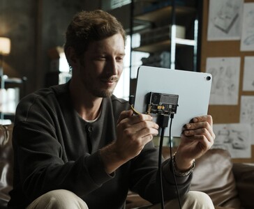 Usuario conectando la unidad SSD portátil transparente Sharge Disk Pro con refrigeración activa a una tableta mediante un cable USB-C. (Sharge vía Kickstarter)