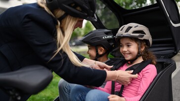 El Cube Trike Family Hybrid puede sentar a dos niños uno al lado del otro en los asientos traseros cubiertos. (Fuente de la imagen: Cube)