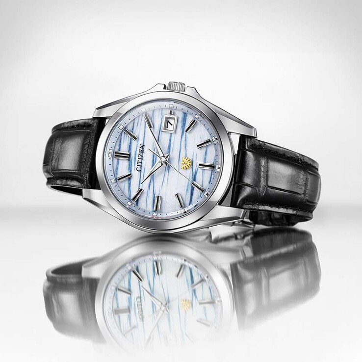 El reloj Citizen AQ4090-08A reposa sobre una superficie reflectante, lo que resalta su esfera de papel washi de color índigo y su correa de piel negra.