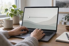 Las manos sobre el teclado de un ordenador portátil; un control deslizante en el extremo izquierdo de la pantalla