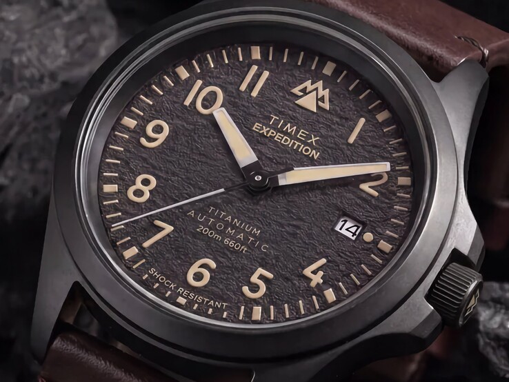 Primer plano de la esfera negra texturizada del Timex Expedition Field Post Titanium, con números arábigos, manecillas e índices luminosos y ventana de fecha.